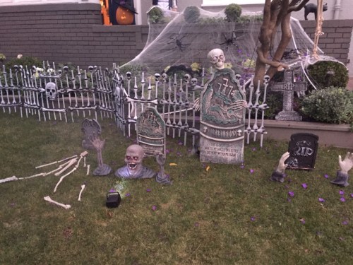 tombstones in a yard decorated for Halloween
